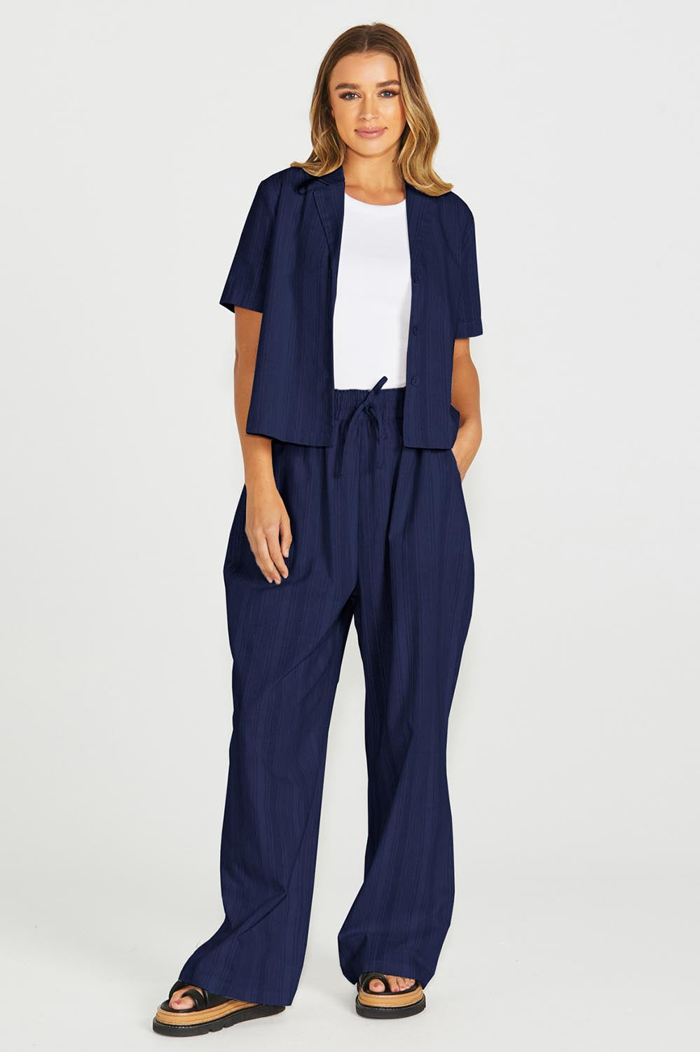 A model wearing the Odell Cotton Linen Pant in colour Navy (Blue), from the front, showing the whole outfit