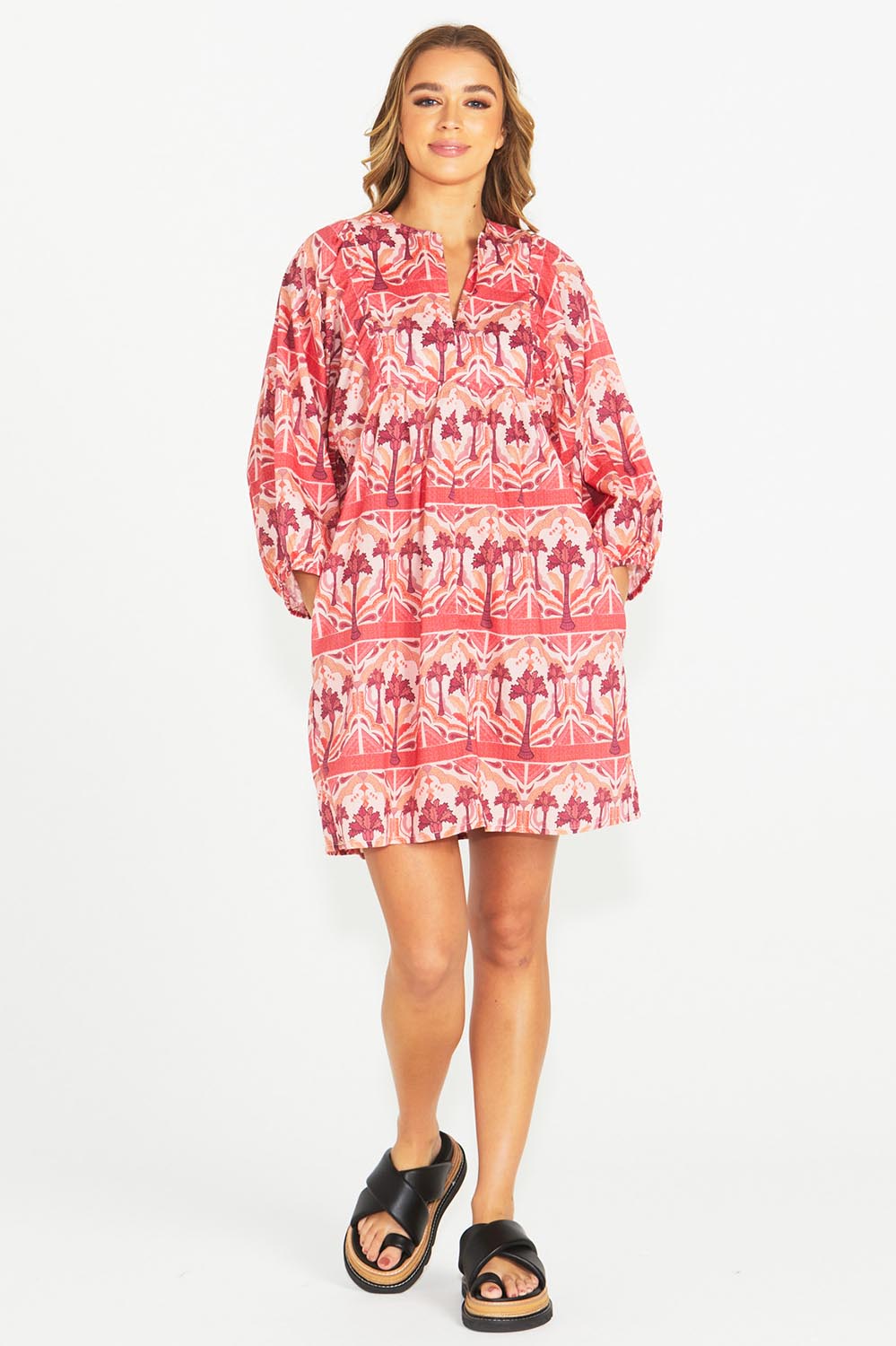 A model wearing the Zayda Cotton Dress in colour Arabian (Pink), from the front, showing the whole outfit