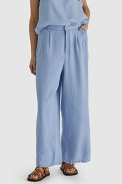 A model wearing the Rye Lyocell Pant in colour Chambray (Blue), from the front, cropped image