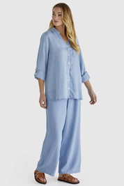 A model wearing the Rye Lyocell Pant in colour Chambray (Blue), from the front, showing the whole outfit