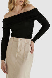 A model wearing the Caprice Top in colour Black (Black), from the front, cropped image