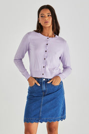 A model wearing the Vale Scalloped Denim Skirt in colour Midblue (Blue), from the front, cropped image