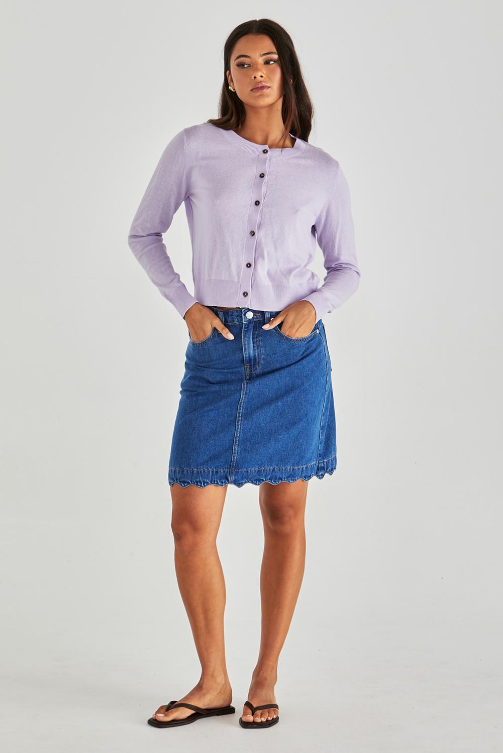 A model wearing the Vale Scalloped Denim Skirt in colour Midblue (Blue), from the front, showing the whole outfit