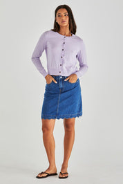 A model wearing the Vale Scalloped Denim Skirt in colour Midblue (Blue), from the front, showing the whole outfit