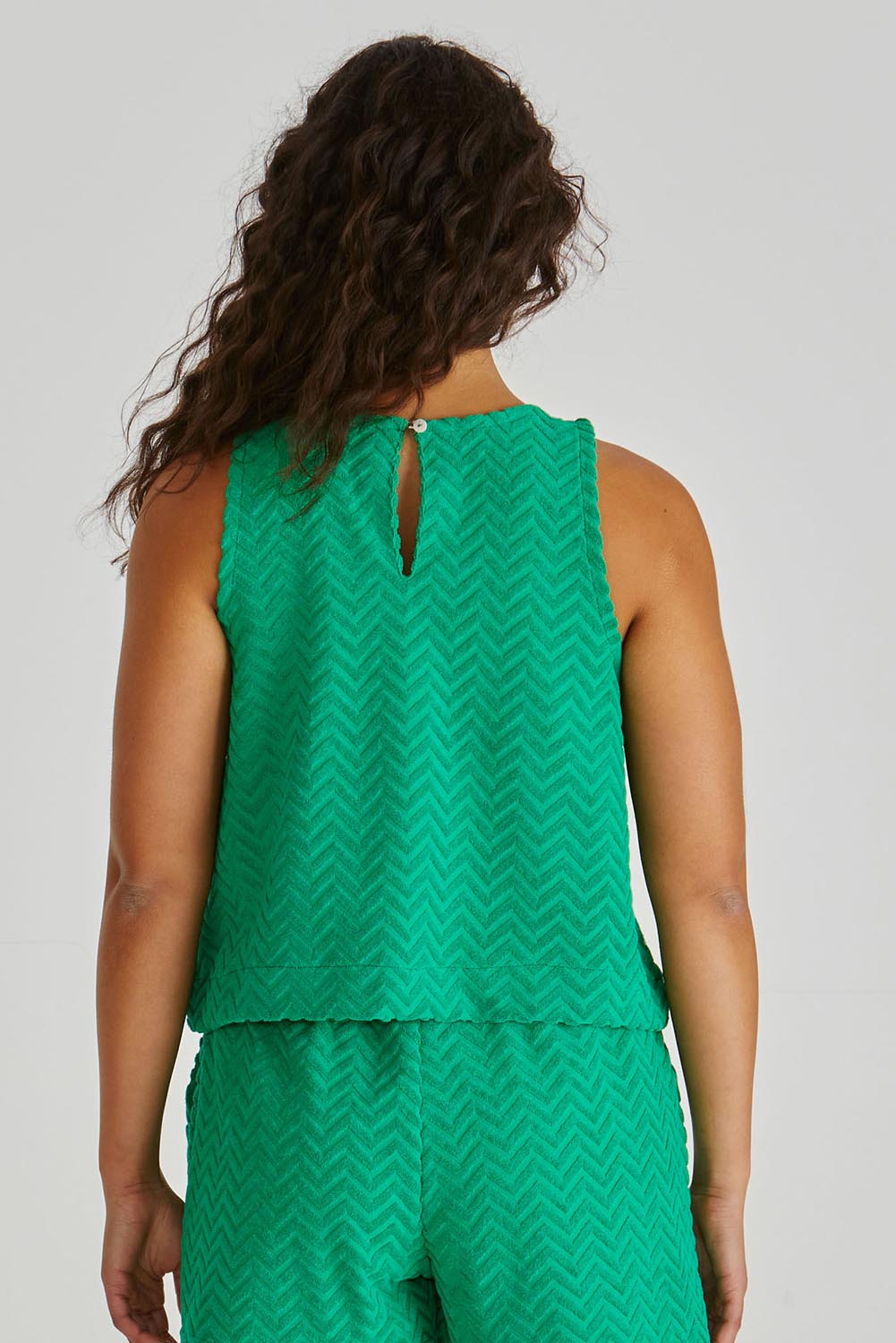 A model wearing the Codi Cotton Blend Tank in colour Green (Green), from the back