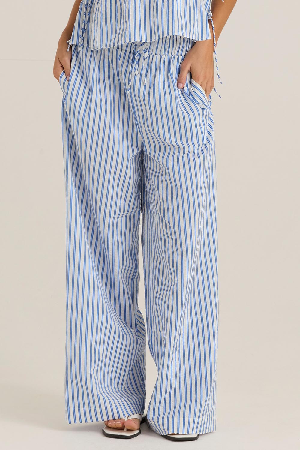 A model wearing the Aziza Pant in colour Bluewhite (Blue), from the front, cropped image