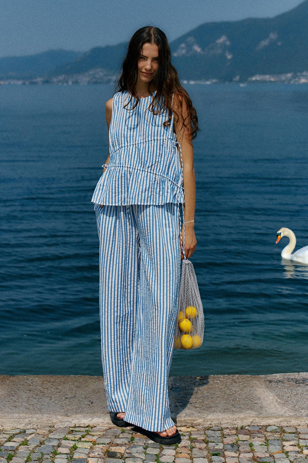 A model wearing the Aziza Pant in colour Bluewhite (Blue), from the front, showing the whole outfit