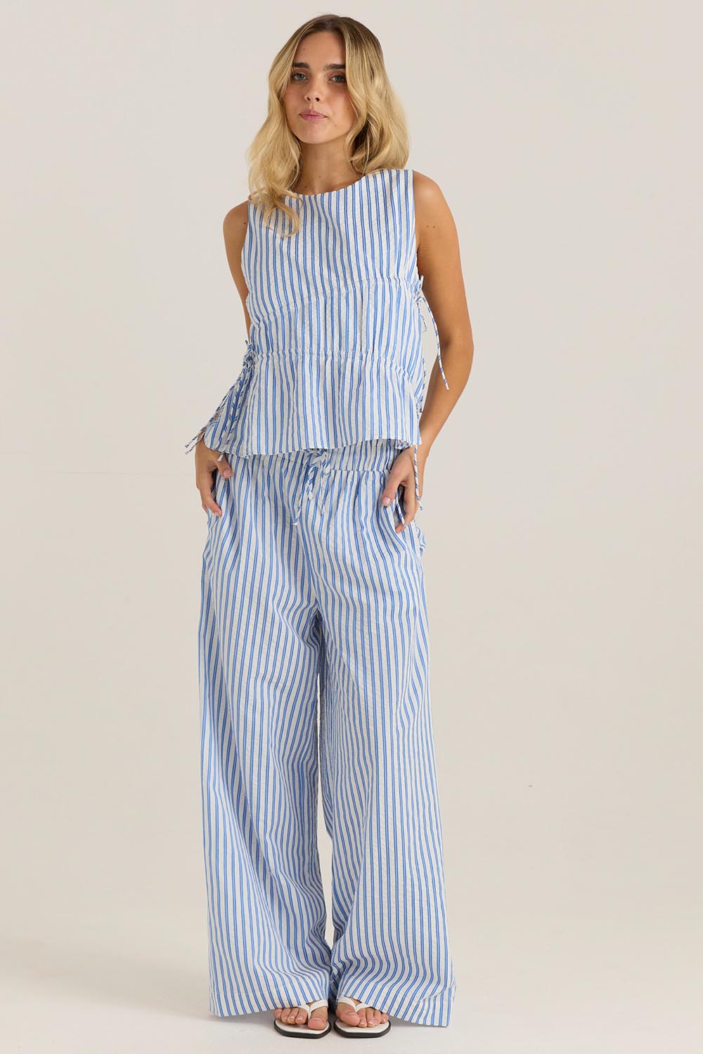 A model wearing the Aziza Pant in colour Bluewhite (Blue), from the front, showing the whole outfit
