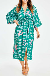 Model Laura wearing size 14 of the Middag Dress in colour Grejuniper (Green), from the front, cropped image