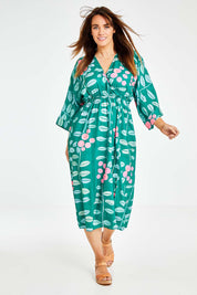 Model Laura wearing size 14 of the Middag Dress in colour Grejuniper (Green), from the front, showing the whole outfit