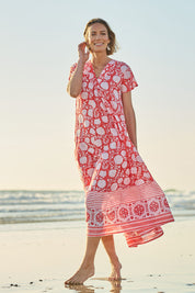 Model Riina wearing size 10 of the Kurrawa Beach Long Cotton Dress in colour Redcoral (Red), from the front, showing the whole outfit
