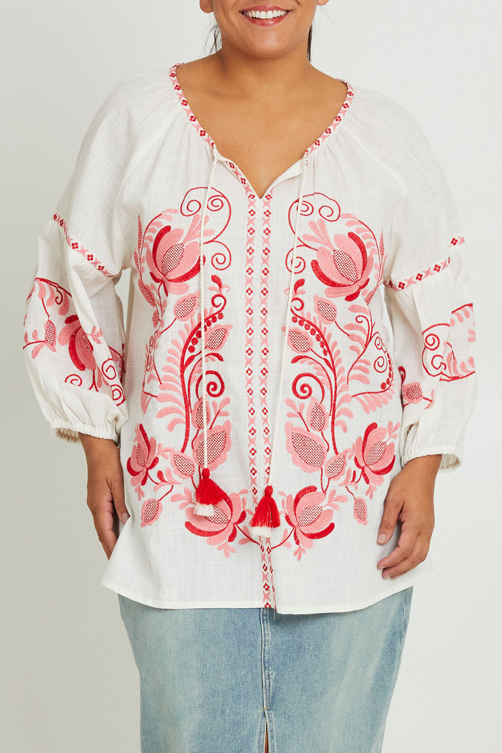 Model Ashleigh wearing size 16 of the Whitehaven Beach Cotton Blouse in colour Whitepink (White), from the front, cropped image
