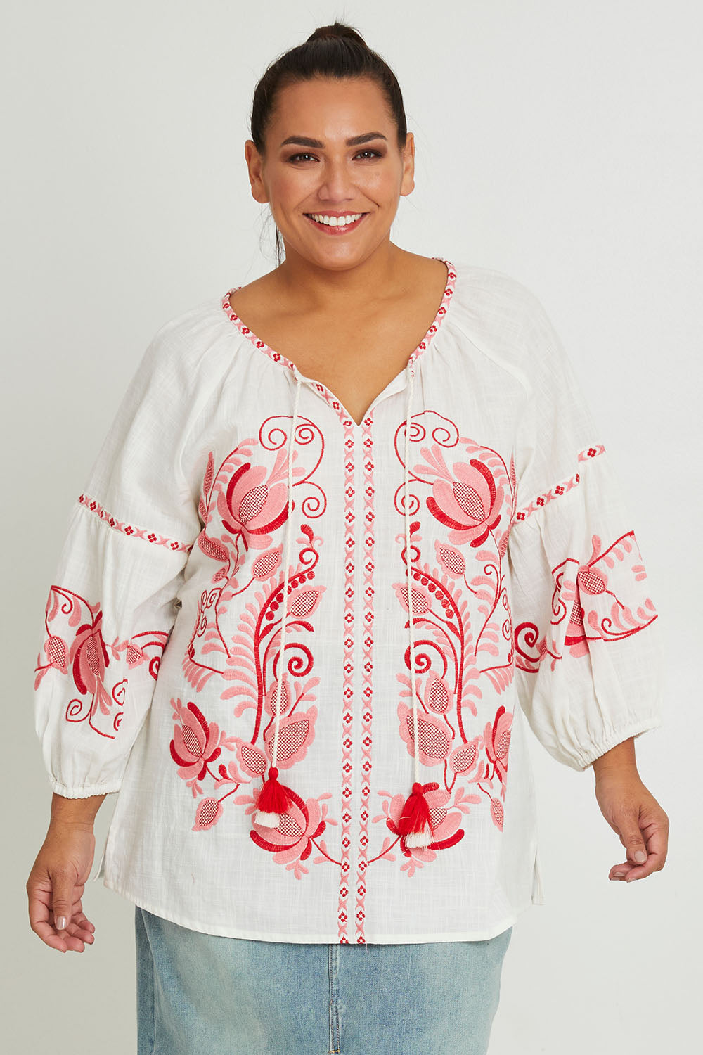 Model Ashleigh wearing size 16 of the Whitehaven Beach Cotton Blouse in colour Whitepink (White), from the front, cropped image