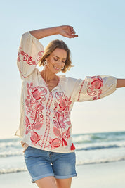Model Riina wearing size 10 of the Whitehaven Beach Cotton Blouse in colour Whitepink (White), from the front, showing the whole outfit