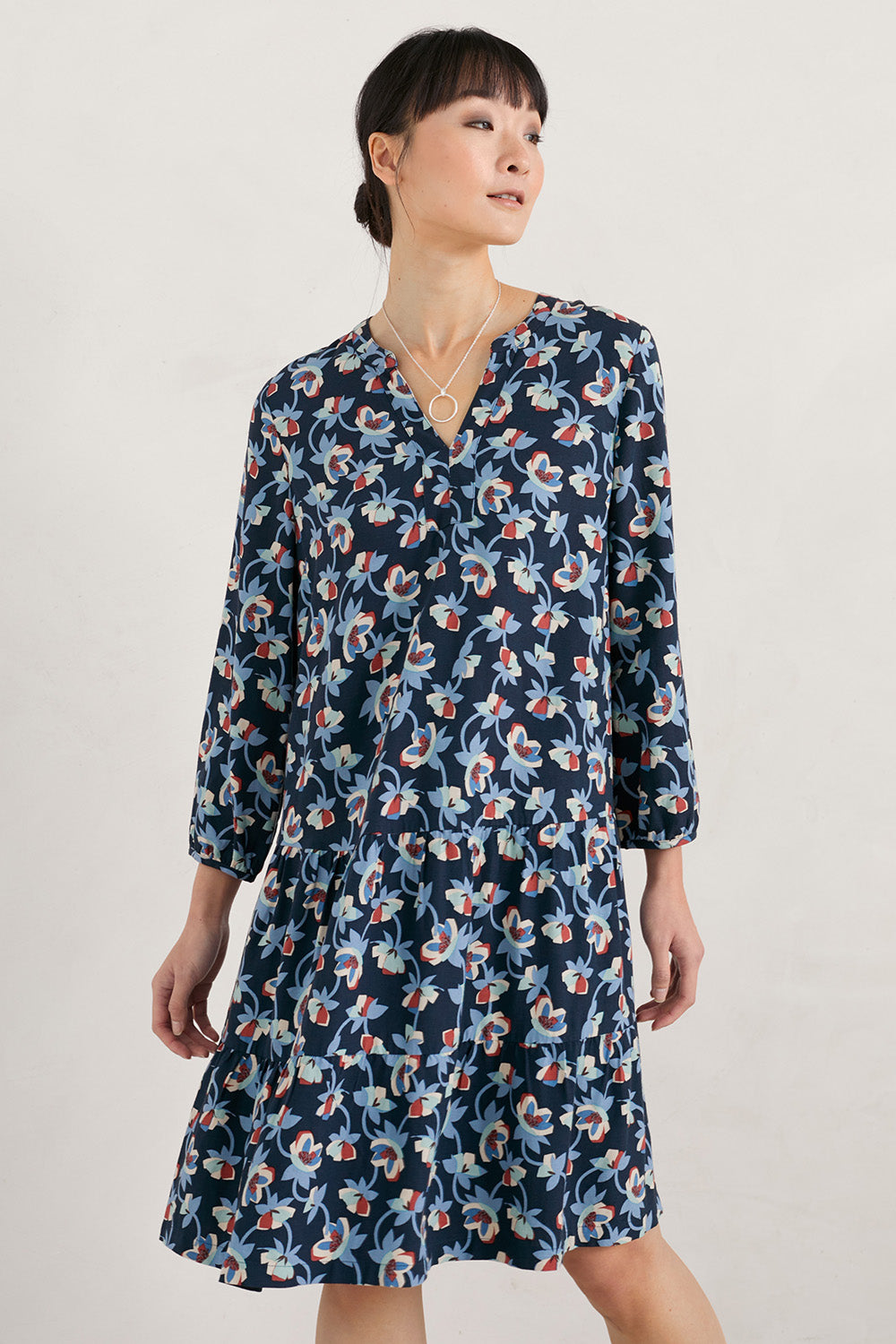 A model wearing the Proctor Dress in colour Hellcoll (Blue), from the front, cropped image