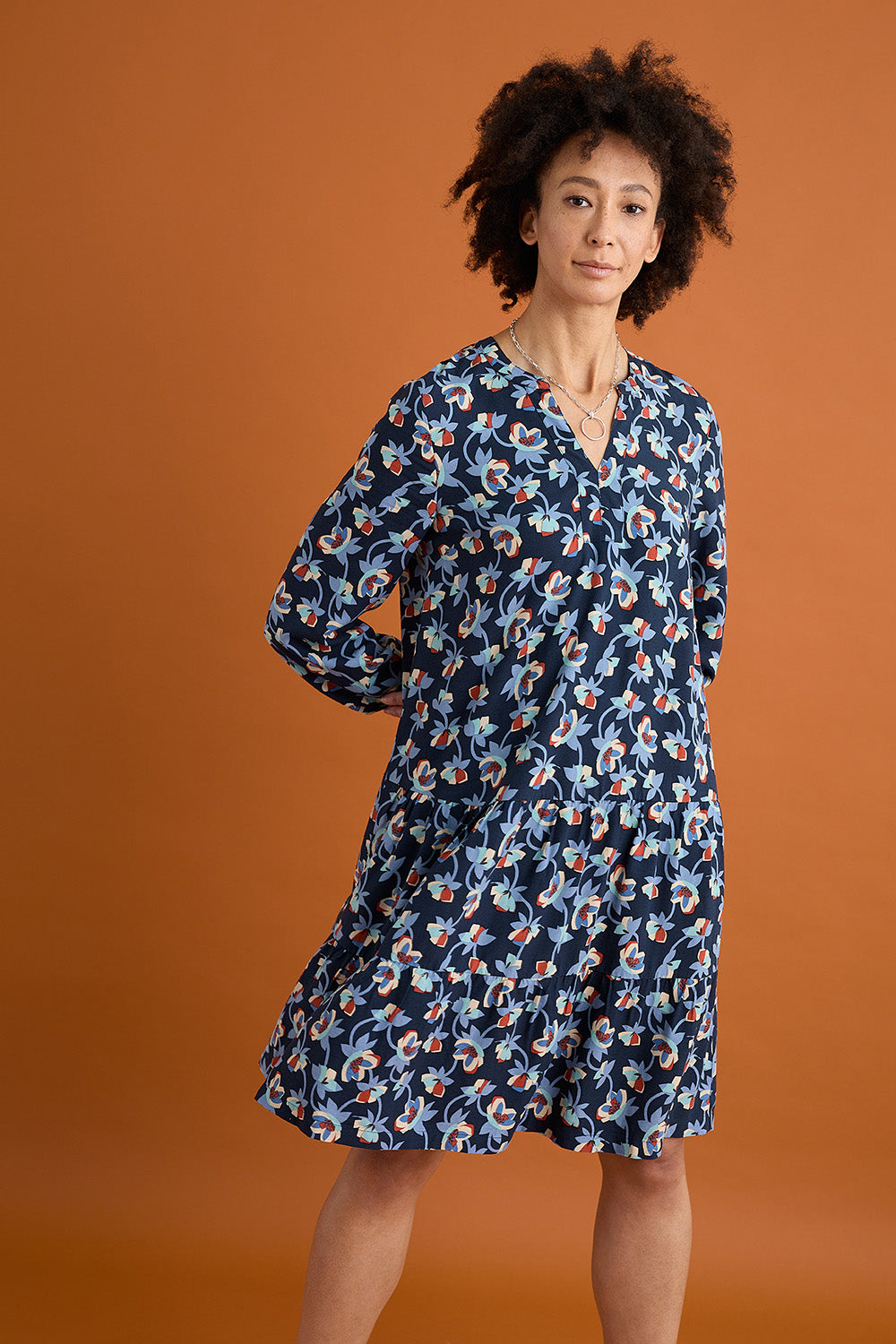A model wearing the Proctor Dress in colour Hellcoll (Blue), from the front, showing the whole outfit