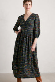 A model wearing the Sea Line Dress in colour Moormeadow (Black), from the front, cropped image