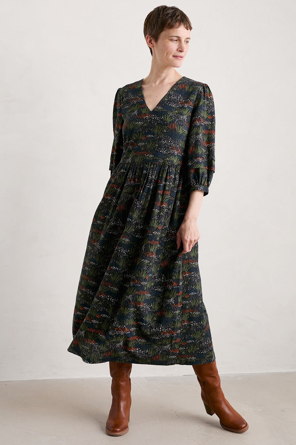 A model wearing the Sea Line Dress in colour Moormeadow (Black), from the front, showing the whole outfit