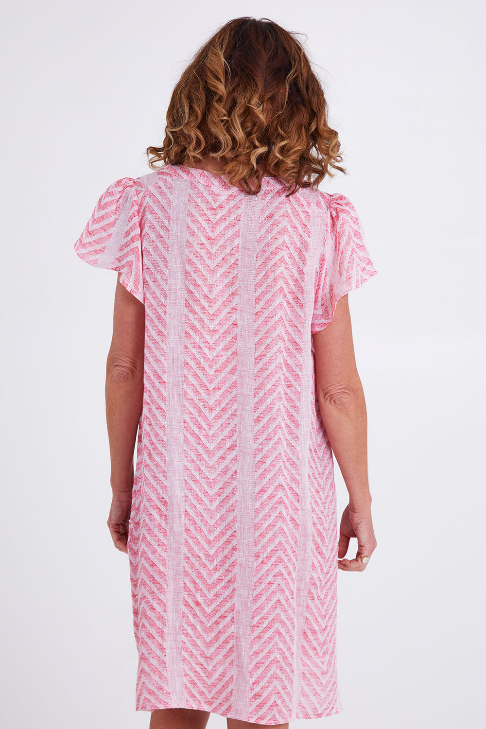 Model Emma wearing size 10 of the Flutter Sleeve Dress in colour Redwhite (Red), from the back
