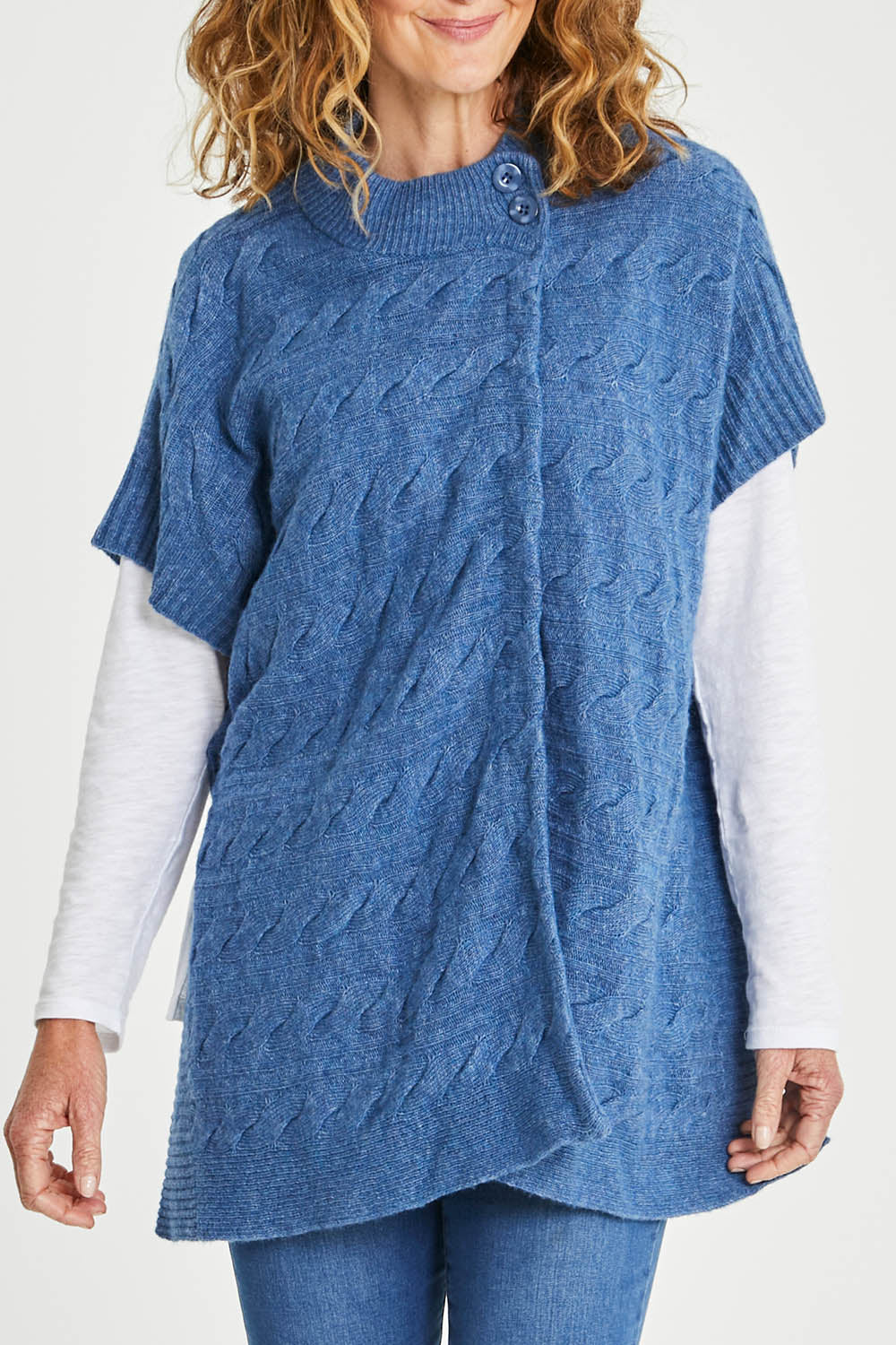 Model Emma wearing size S of the Lambswool Blend Cable Poncho in colour Denim (Blue), from the front, cropped image