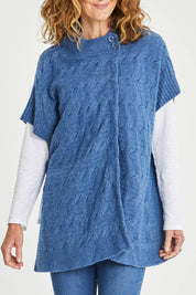 Model Emma wearing size S of the Lambswool Blend Cable Poncho in colour Denim (Blue), from the front, cropped image