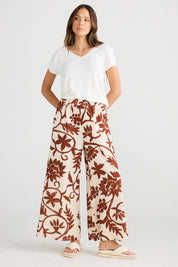 A model wearing the Positano Pant in colour Cubanbloom, from the front, showing the whole outfit