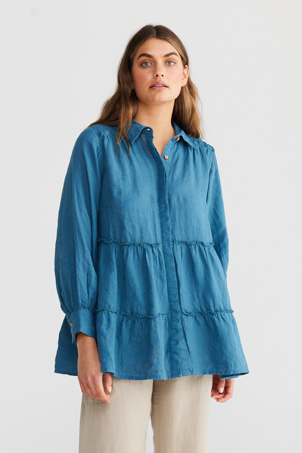 A model wearing the Mia Top in colour Bluesteel (Blue), from the front, cropped image