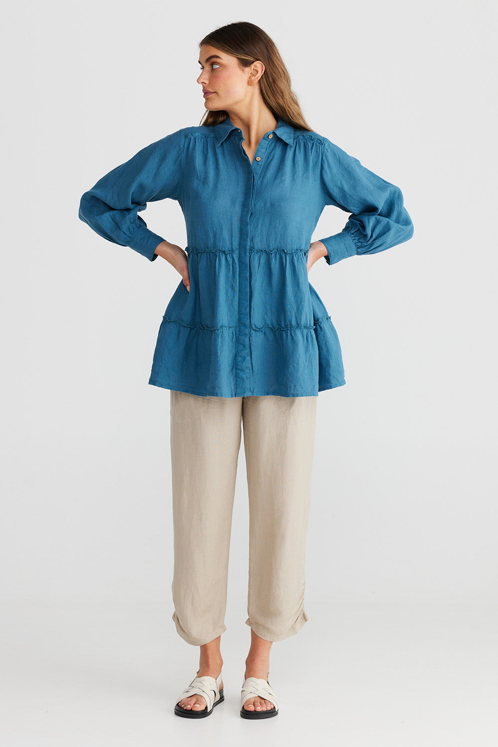 A model wearing the Mia Top in colour Bluesteel (Blue), from the front, showing the whole outfit