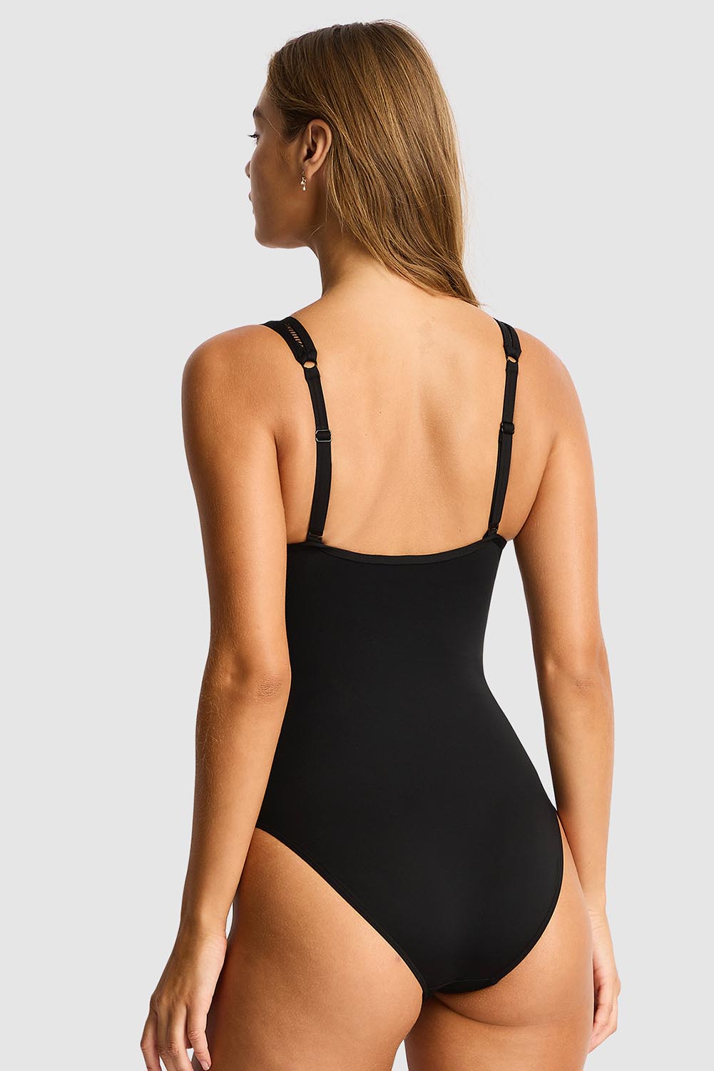 A model wearing the Spliced One Piece in colour Black (Black), from the back