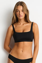 A model wearing the Square Neck Bra Top in colour Black (Black), from the front, cropped image