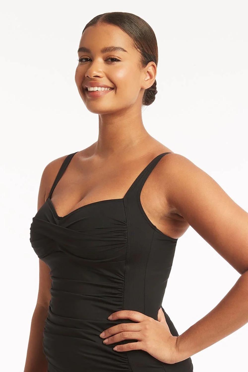 A model wearing the Twist Front Multifit Singlet Top in colour Black (Black), from the front, cropped image