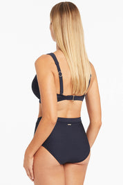A model wearing the Amazing Lace Cross Front Panelled Bralette in colour Nightsky (Blue), from the back