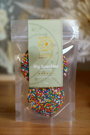 A model wearing the 120G Milk Chocolate Big Speckles in colour Speckles, from the front, showing the whole outfit