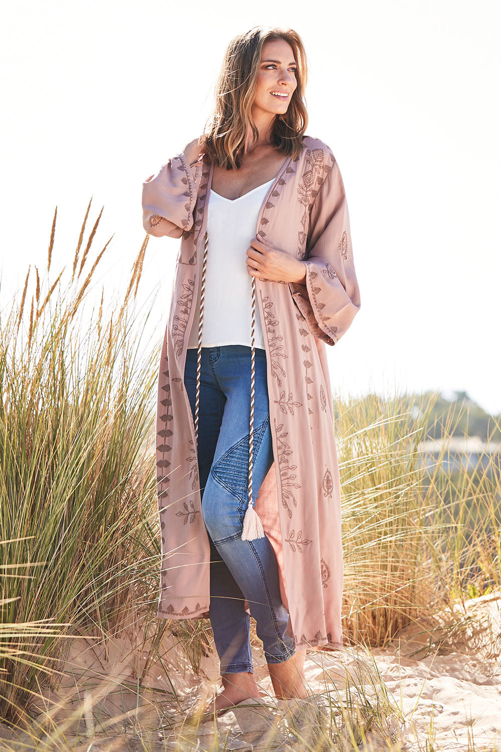Model Riina wearing size OneSize of the Lorenzo Cape in colour RoseSmoke (Pink), from the front, showing the whole outfit