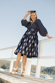 Model Phoebe wearing size S of the Gaia Dress in colour Navy (Blue), from the front, showing the whole outfit