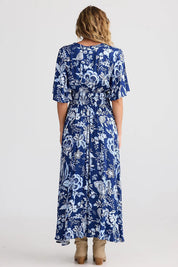 A model wearing the Harlow Dress in colour Celestial (Blue), from the back