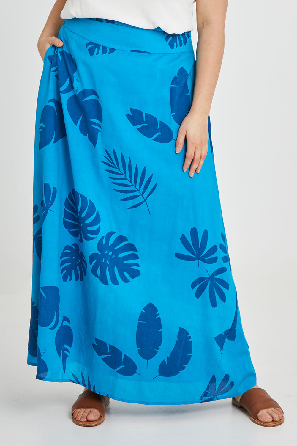 Model Keeara wearing size 16 of the Rosie Maxi Skirt in colour Palm (Blue), from the front, cropped image