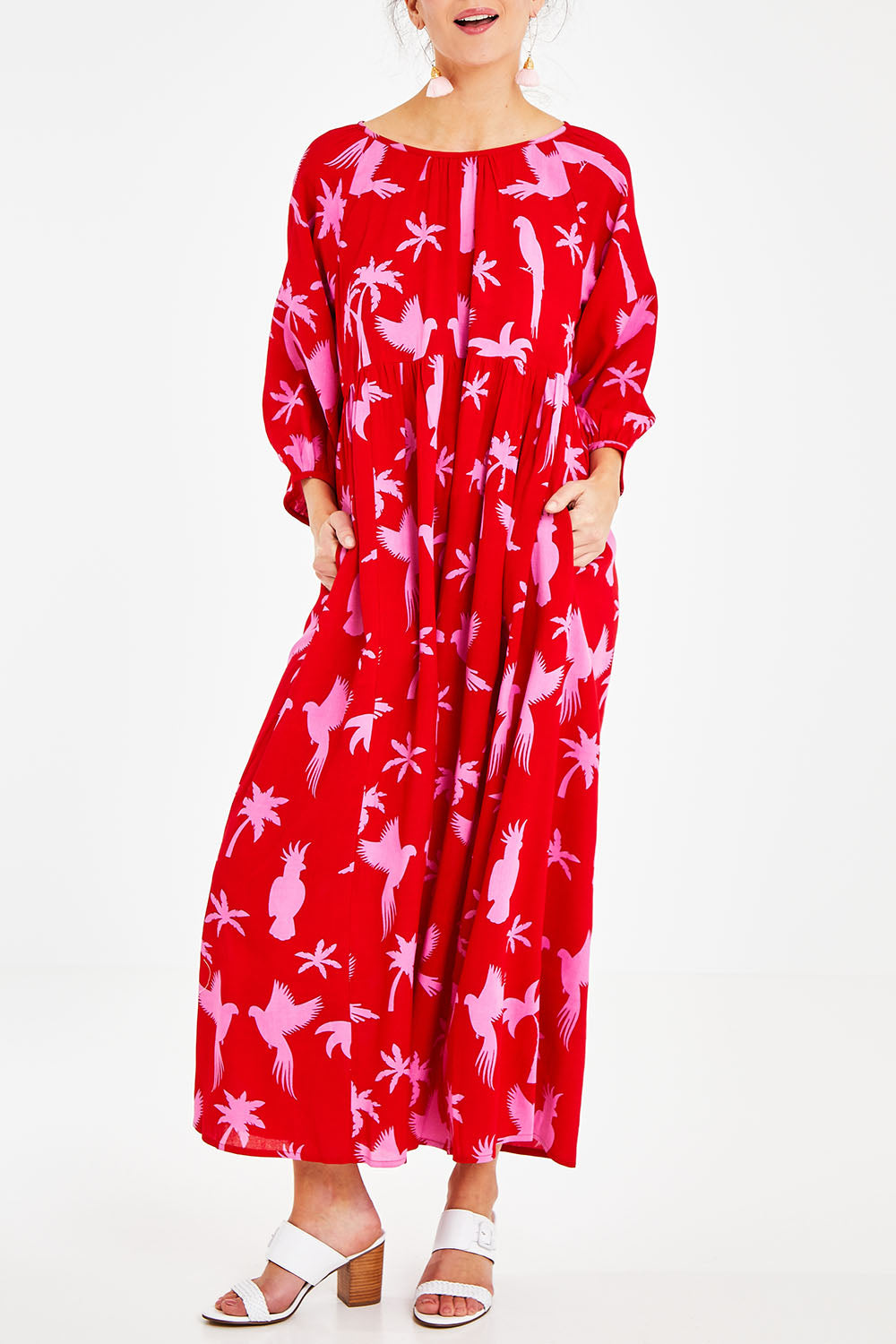 Model Courtney wearing size 10 of the Alice Gathered Dress in colour Bird (Red), from the front, cropped image