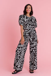 Model Natalie wearing size 10 of the Rachel Bell Sleeve Top in colour Vines (Black), from the front, showing the whole outfit