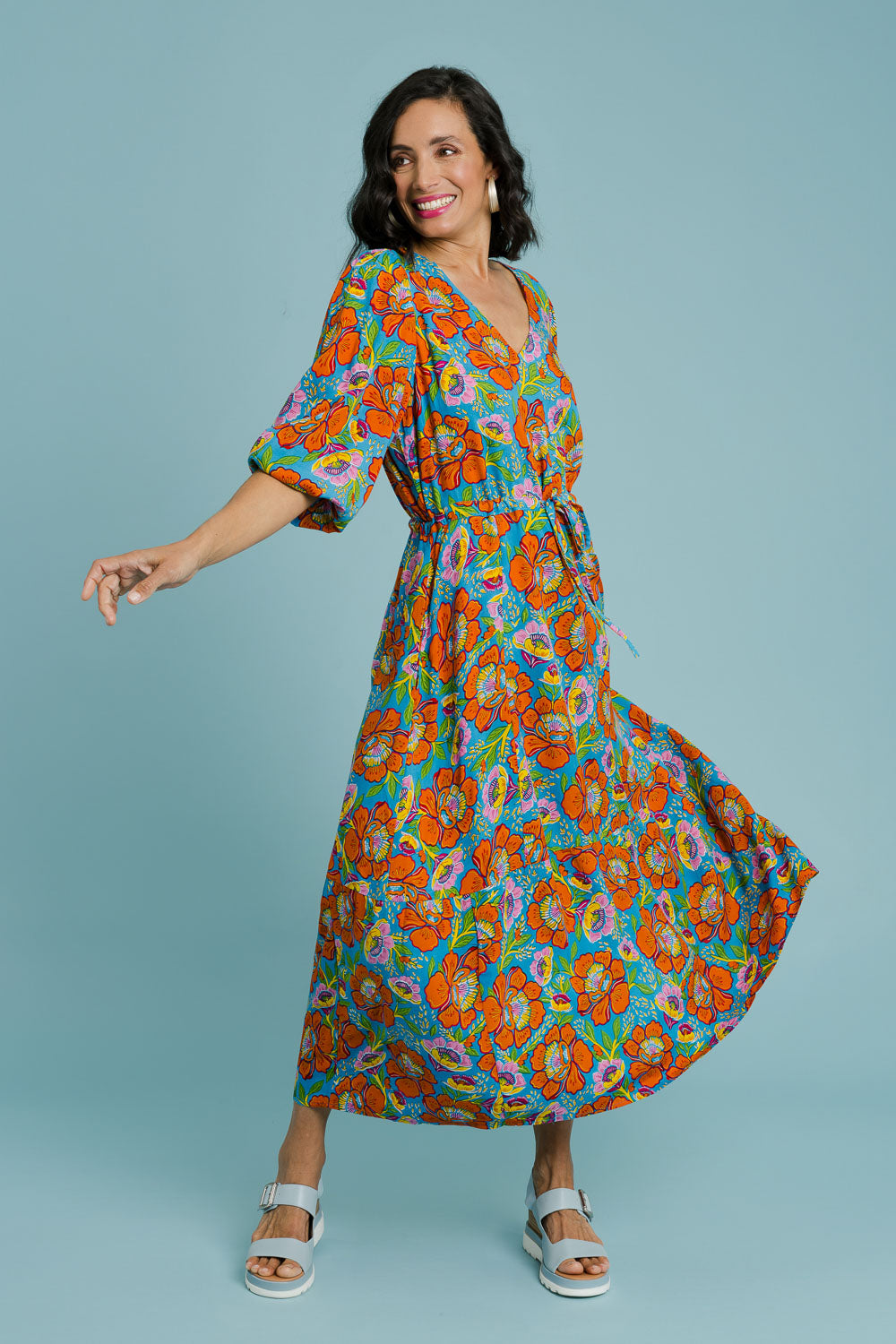 Model Natalie wearing size 10 of the Gabriella Dress in colour Carnations (Blue), from the front, showing the whole outfit