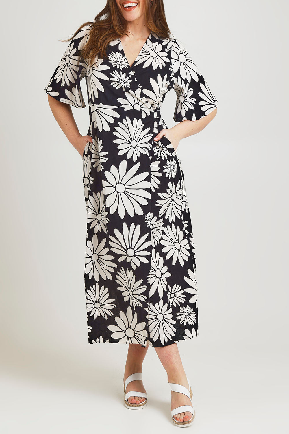 Model Jane wearing size 14 of the Gloria Cotton Wrap Dress in colour Bolddaisy (Black), from the front, cropped image