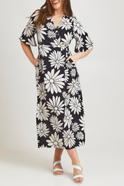 Model Jane wearing size 14 of the Gloria Cotton Wrap Dress in colour Bolddaisy (Black), from the front, cropped image