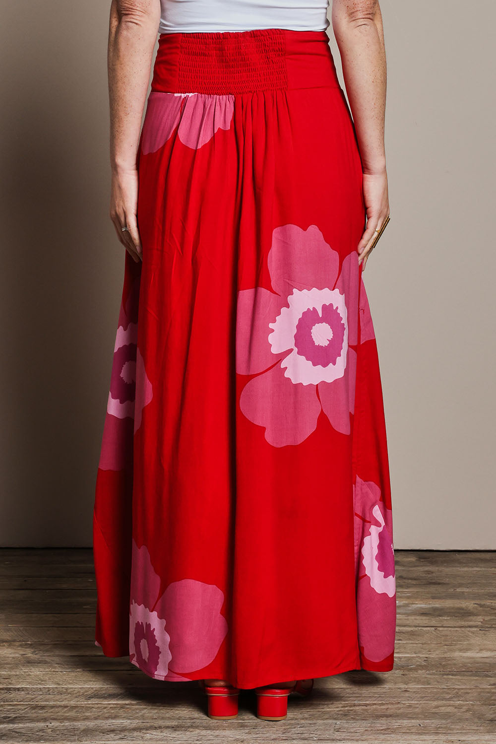 Model Katie wearing size 10 of the Rosie Maxi Skirt in colour Boldred (Red), from the back