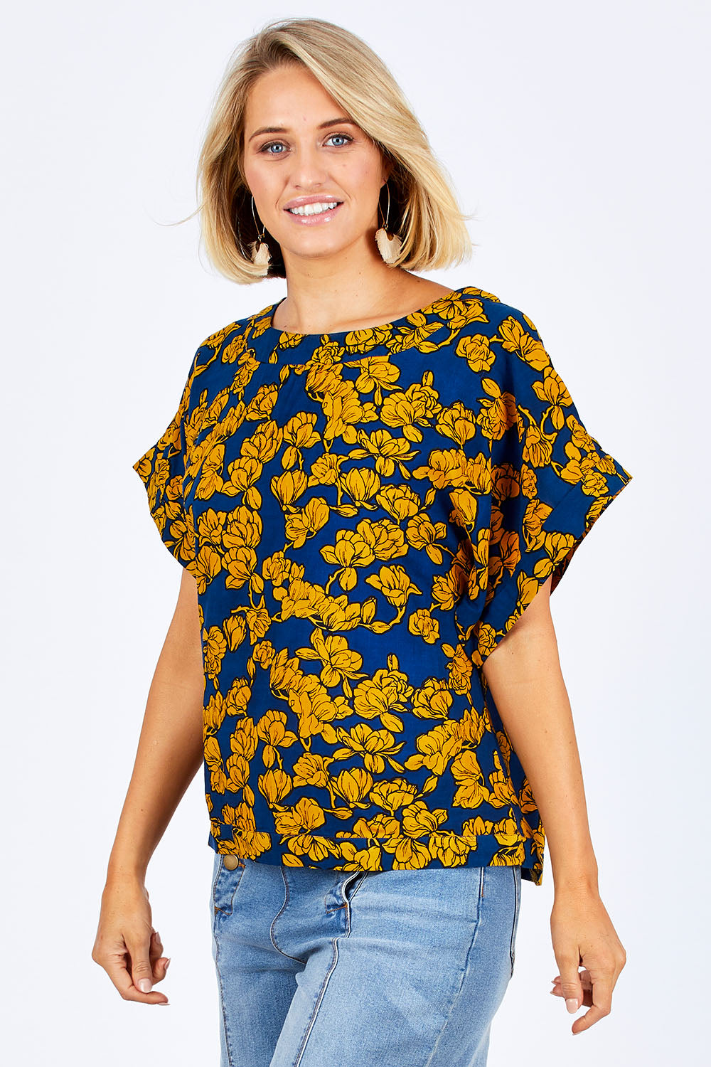 Model Emma wearing size 10 of the Lola Bell Sleeve Top Entangled Vines in colour Gold, from the front, cropped image
