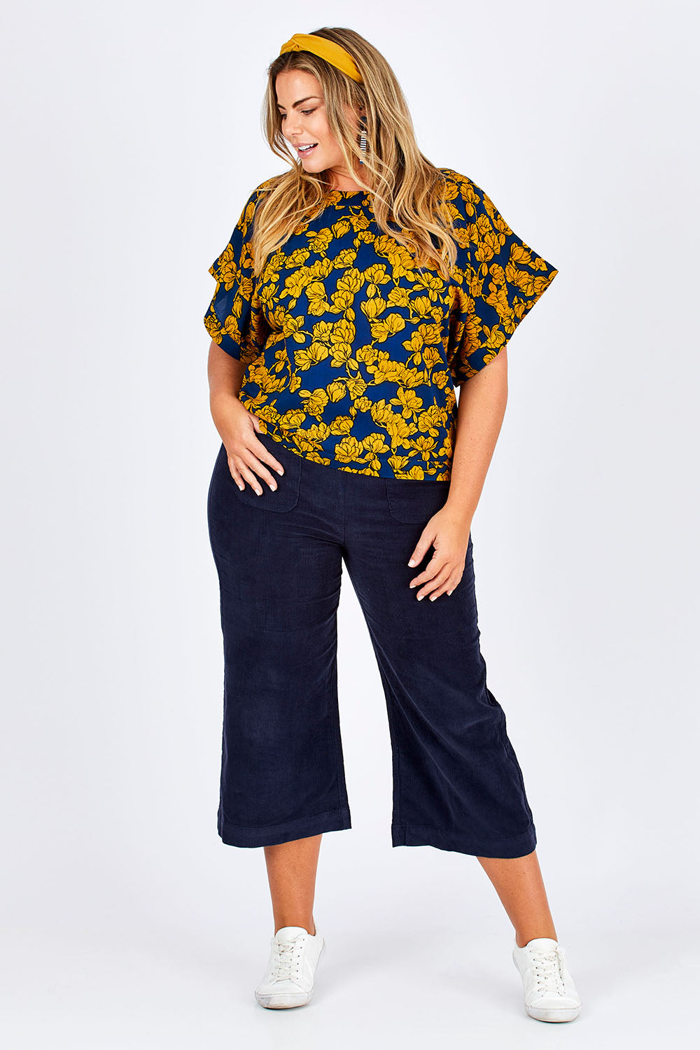 Model Fiona wearing size 16 of the Lola Bell Sleeve Top Entangled Vines in colour Gold, from the front, showing the whole outfit