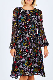 Model Emma wearing size 10 of the Odette Dress Garden Dweller in colour Black (Black), from the front, cropped image
