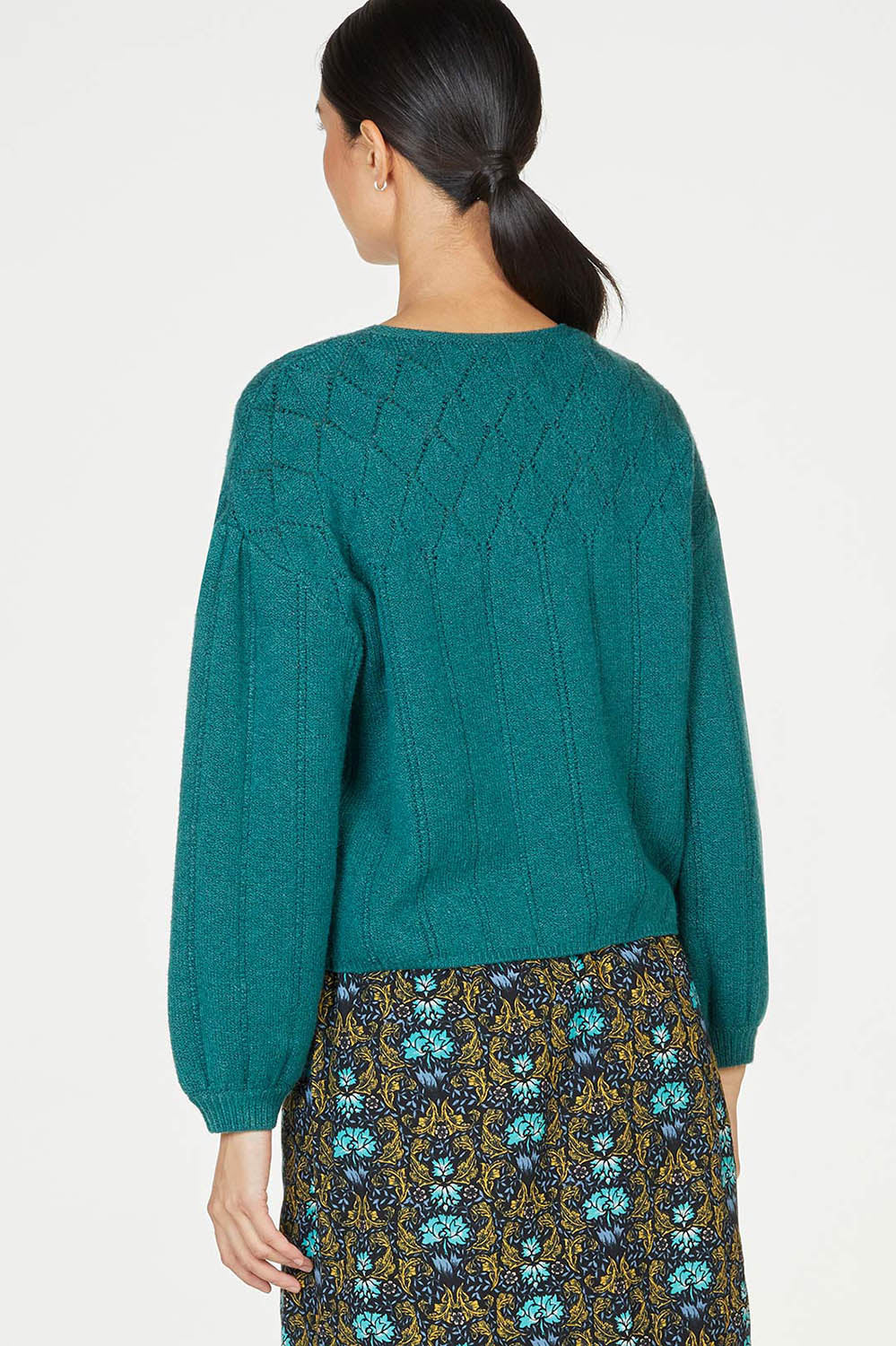 A model wearing the Bennedetta Pointelle Jumper in colour Malgreen (Green), from the back