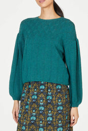 A model wearing the Bennedetta Pointelle Jumper in colour Malgreen (Green), from the front, cropped image