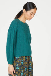 A model wearing the Bennedetta Pointelle Jumper in colour Malgreen (Green), from the front, cropped image