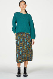 A model wearing the Bennedetta Pointelle Jumper in colour Malgreen (Green), from the front, showing the whole outfit